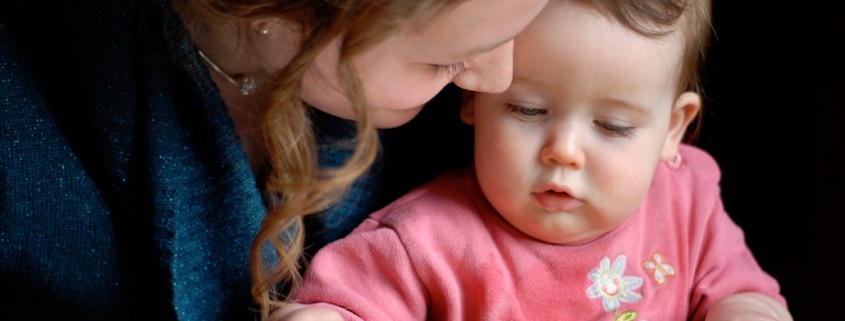 mother reads to infant daughter