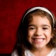 smiling young girl against red background
