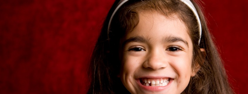 smiling young girl against red background