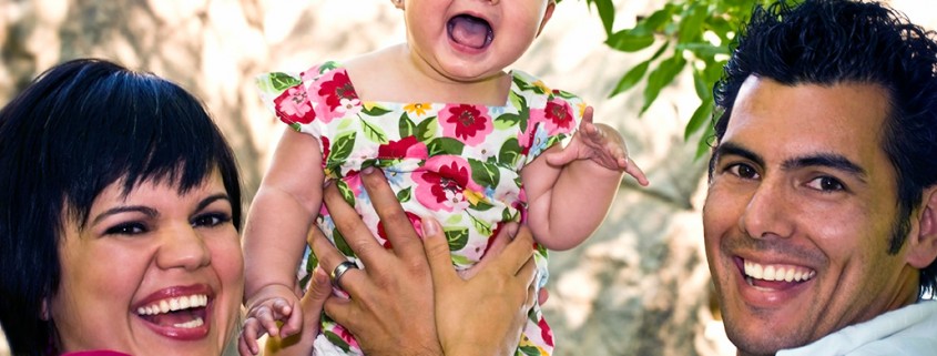 parents lift laughing baby