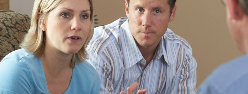 parents speaking with authoritative man
