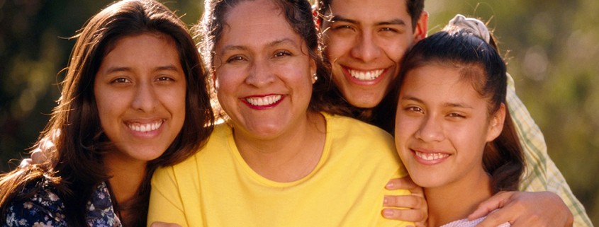 family of four smiles for camera