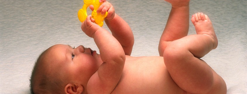 infant plays with plastic toy