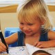 young girl drawing in coloring book