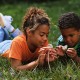 boy and girl play with dandelions