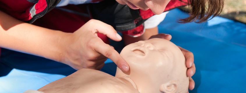 Practicing First Aid and CPR on infant dummy