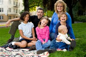 family of six sitting on grass