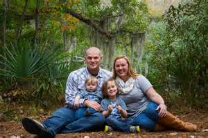 parents and two young children sitting on grass