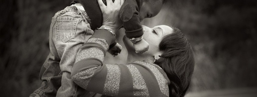 mother lifting and kissing a baby