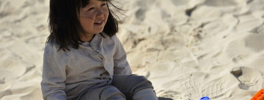 young child playing in the sand