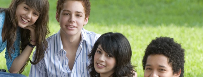 pre-teens sitting on grass