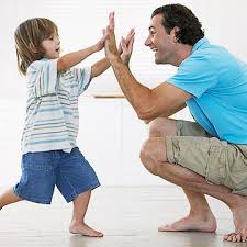 Young boy "high-five's" father with both hands