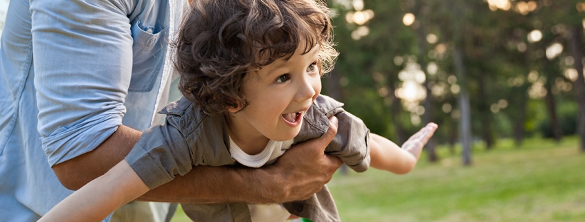 Young boy is carried by his father as if "flying"